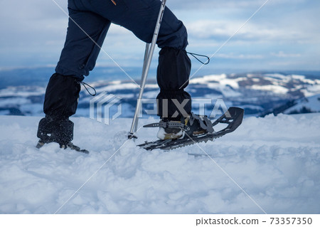 A snow shoe hiker walking along the ridge of Kronberg, a mountain in Switzerland A snow shoe hiker walking along the ridge of Kronberg, a mountain in Switzerland 73357350