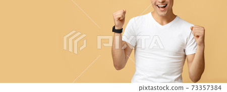 Male champion achieves great effective results. Excited young man with joy, expresses emotions of victory 73357384