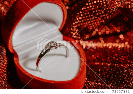 Close up of white gold engagement ring with a diamond, marriage proposal concept Close up of white gold engagement ring with a diamond, marriage proposal concept 73357581