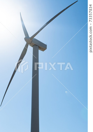 Frontal view of wind turbine in nature in sunshine Frontal view of wind turbine in nature in sunshine 73357834