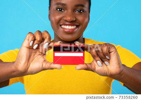 Black Lady Showing Credit Card To Camera Over Blue Background 73358260