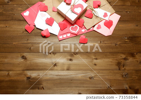 Love, Valentine's, women's day, relations, romantic template from gifts and love letters, colored and wrapped in craft paper, tied with twine with bows and labels, hearts on wood background 73358844