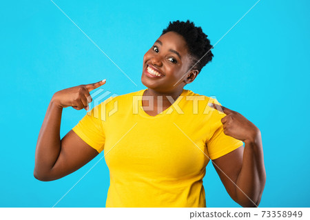 Confident Plus-Size Black Woman Pointing Fingers At Herself, Blue Background 73358949