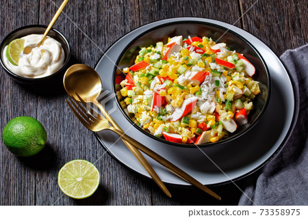 Crab salad on a dark wooden background, top view 73358975