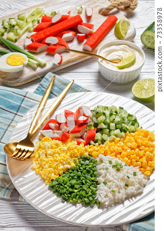 Crab salad of surimi sticks on a white plate Crab salad of surimi sticks on a white plate 73358978