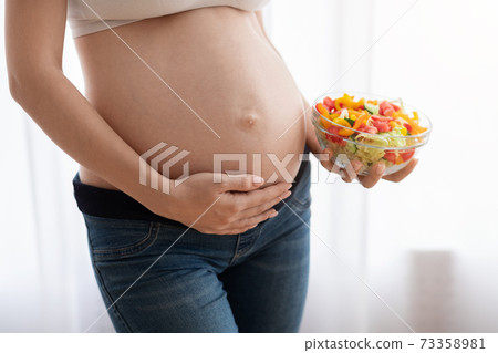 Nutrition For Healthy Pregnancy. Pregnant Woman Holding Vegetable Salad Bowl Near Belly Nutrition For Healthy Pregnancy. Pregnant Woman Holding Vegetable Salad Bowl Near Belly 73358981
