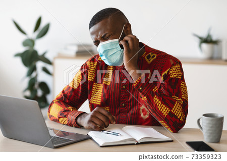 Stressed Black Man In Protective Medical Mask Scratching Face, Having Itchy Skin 73359323
