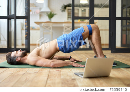 Handsome young man doing exercise with elastic fitness band Handsome young man doing exercise with elastic fitness band 73359540
