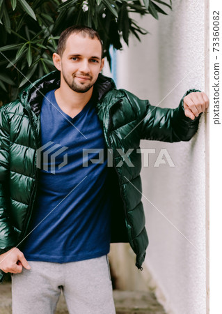 man wearing blue t-shirt mockup and jacket outdoors 73360082