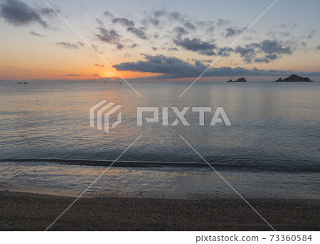 Sunrise with the red orange sun raising up from the sea with dark clouds at beach Spiaggia di Santa Maria Navarrese, Sardinia, Italy Sunrise with the red orange sun raising up from the sea with dark clouds at beach Spiaggia di Santa Maria Navarrese, Sardinia, Italy 73360584