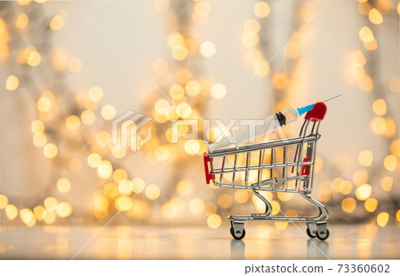 syringe injection in shopping cart for coronavirus vaccine disease, covid-19 or other virus, vaccination shot, medicine and drug concept bokeh background 73360602