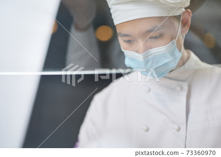 Thoughtful Asian cook being concentrated on work 73360970