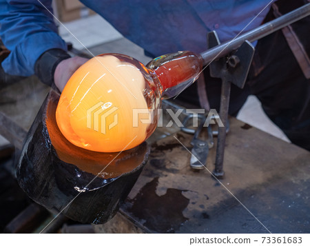 Shaping the red melted glass on glassblowing pipe Shaping the red melted glass on glassblowing pipe 73361683