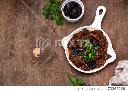 Hot stewed meat with prunes 73362266