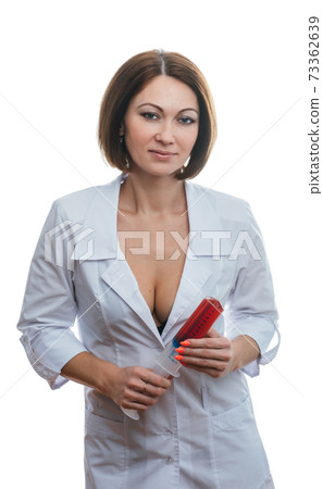 Sexually doctor woman on isolated white background. Caucasian woman medic with big syringe with a red liquid. Sexually doctor woman on isolated white background. Caucasian woman medic with big syringe with a red liquid. 73362639