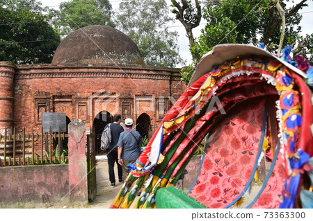Sional Gao in Dhaka, Bangladesh A man sightseeing with the historic Goardi Mosgit and a parked rickshaw 73363300