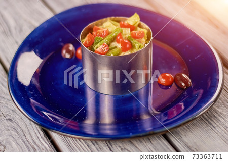 Vegetables in steel bowl on plate. Vegetables in steel bowl on plate. 73363711