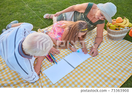 Little girl drawing, grandparents. Little girl drawing, grandparents. 73363908