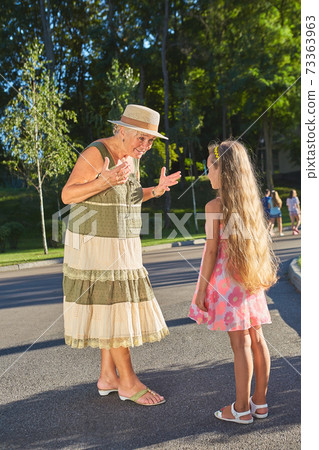 Senior woman with granddaughter, summer. Senior woman with granddaughter, summer. 73363963