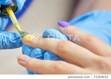 Painting nails with polish close up. Painting nails with polish close up. 73364645