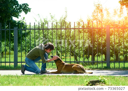 The woman is praising her dog. 73365027