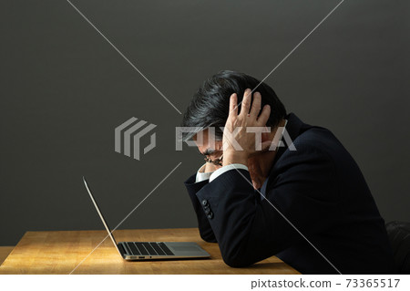 Business image A man holding his head Business image A man holding his head 73365517