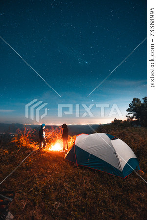 Camping tents and bonfires in the night and the stars 73368995