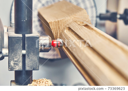 Turning wooden stair balusters. Wood stair balusters manufacturing process on a turning lathe with milling cutter 73369623