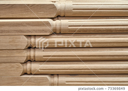 Turning wooden stair balusters. Wood stair balusters stacked in workshop Turning wooden stair balusters. Wood stair balusters stacked in workshop 73369849
