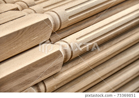 Turning wooden stair balusters. Wood stair balusters stacked in workshop 73369851