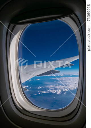 The airplane wing view from aeroplane window with beautiful atmosphere blue sky clouds background. The airplane wing view from aeroplane window with beautiful atmosphere blue sky clouds background. 73369928