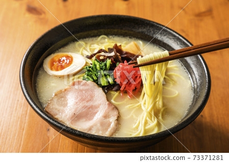Tonkotsu ramen lifted with chopsticks 73371281