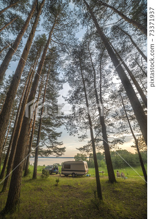 camper in the forest by the lake 73371937