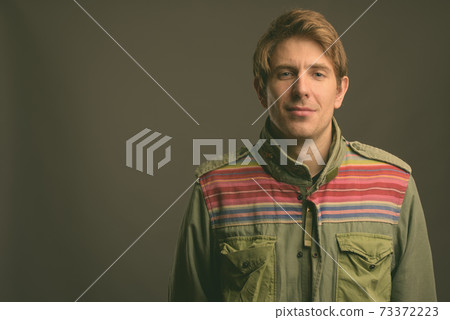 Handsome man against gray background Handsome man against gray background 73372223