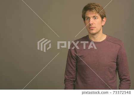 Handsome man against gray background 73372548