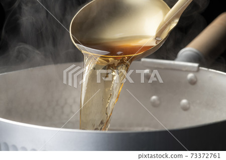 Scoop the soup stock with a ladle Scoop the soup stock with a ladle 73372761