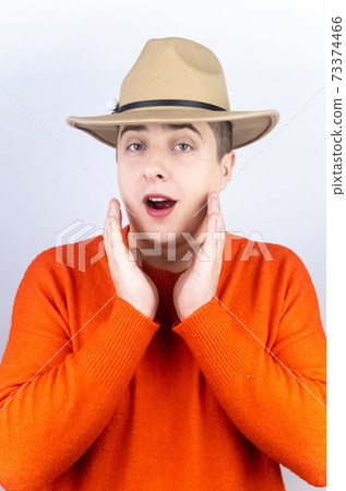 A man with painted lips, wearing women's clothing and makeup, stands in front of a mirror and admires himself. Protecting the rights of the LGBT community and openly manifesting homosexuality. 73374466