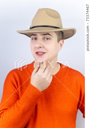 A man with painted lips, wearing women's clothing and makeup, stands in front of a mirror and admires himself. Protecting the rights of the LGBT community and openly manifesting homosexuality. 73374467