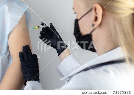 An allergist in the laboratory conducts an allergy prick-test. Skin test for household, food, epidermal allergic reactions. The test is performed on the patient back 73375588