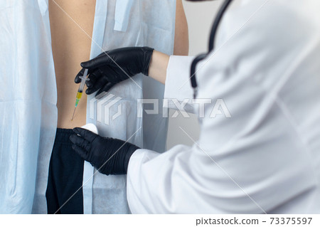 An allergist in the laboratory conducts an allergy prick-test. Skin test for household, food, epidermal allergic reactions. The test is performed on the patient back 73375597
