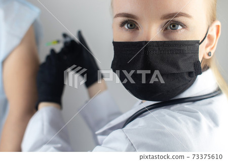 An orthopedic surgeon gives an injection in the elbow. Treatment of osteoarthritis with hormonal drugs or drugs based on hyaluronic acid. Help with diseases that damage the cartilage of the joint 73375610