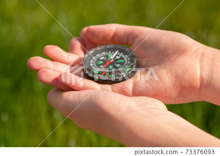Old classic navigation compass in childs hands 73376093