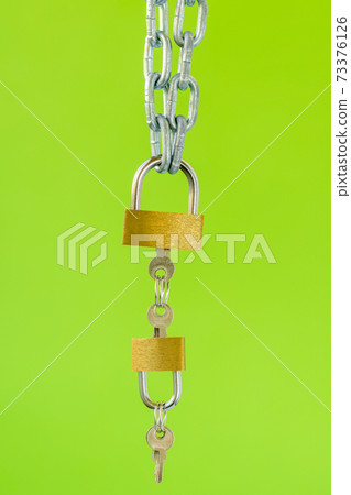 Padlocks with keys hanging on the metal chain Padlocks with keys hanging on the metal chain 73376126