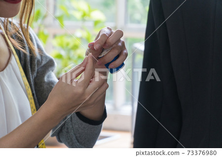 Focus woman hand sewing the needle. Focus woman hand sewing the needle. 73376980