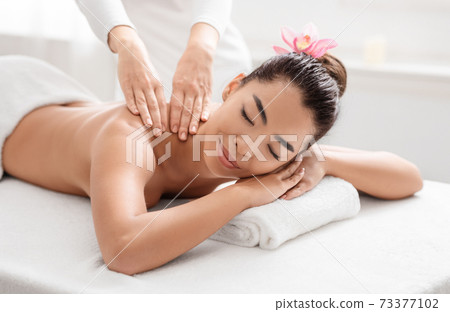 Wellness Concept. Attractive Asian Woman Relaxing During Thai Massage Session At Salon Wellness Concept. Attractive Asian Woman Relaxing During Thai Massage Session At Salon 73377102
