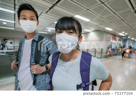 Asian couple wearing health mask for travel by subway at Thailand 73377104