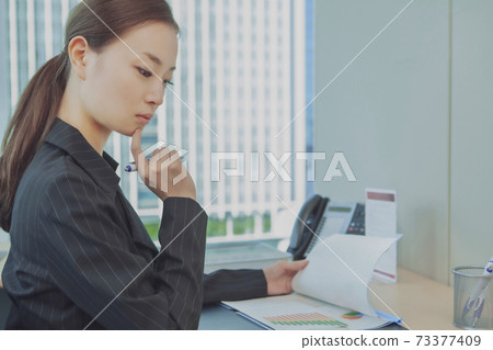 Business woman to check documents Business woman to check documents 73377409