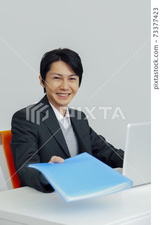 當前帶著微笑的文件的商人 當前帶著微笑的文件的商人 73377423