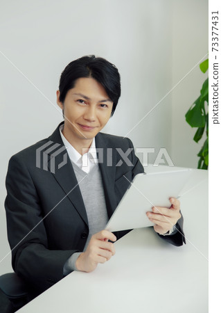 A businessman with a tablet PC 73377431