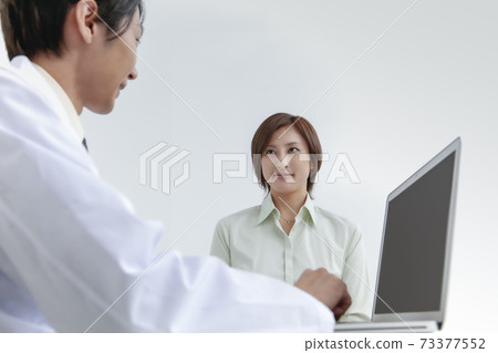 一名婦女與一位男性醫生談話 73377552